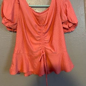 A pink ruffled shirt